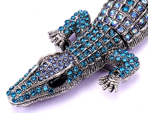 Close-up of crocodile brooch with blue rhinestones and sparkling crystal scales