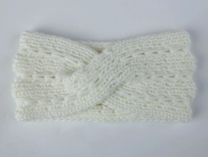 Detail of cream-white chunky knit headband with elegant twisted cross-weave pattern