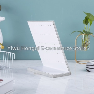 Close-up of L-shaped white velvet earring display stand with multi-hole design