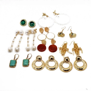 Collection of gold alloy earrings with pearls and emerald stones on white background