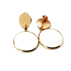 Close-up of gold tone clip-on earrings with white circular pearl shell inlay details