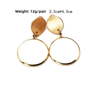 Detail of golden geometric alloy earrings with white circular inserts, 2.5cm by 4.5cm