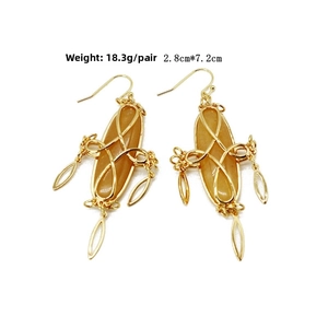 Detail of bohemian wire-wrapped earring with amber stone and hollow leaf charms