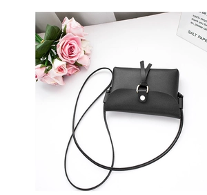Detailed top view of a black mini crossbody bag with metal ring buckle and floral decor