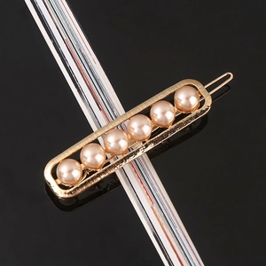 Close-up of golden alloy hairpin inlaid with six elegant light pink faux pearls