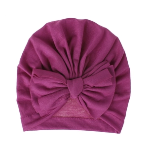 Dettaglio cappello a turbante per neonati viola scuro con grande fiocco a tre strati