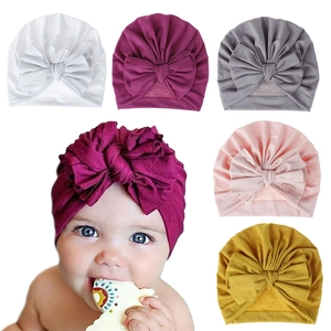 Soft cotton baby turban hats with large decorative bow shown in five vibrant colors