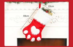 Detail of red dog paw Christmas stocking showing 44cm height and white plush texture