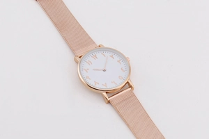 Detailansicht des Roségold-Mesh-Armbands und weißes Zifferblatt mit arabischen Ziffern