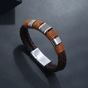 Close-up of brown braided leather bracelet with orange thread and silver magnetic clasp