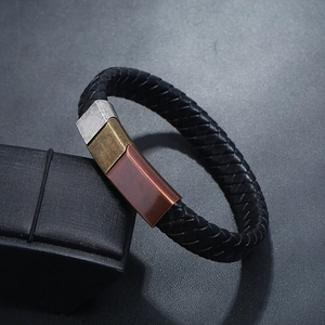 Detailed macro shot of braided black leather bracelet with multi-color antique metal clasps