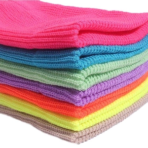 Pile of colorful ribbed knit dock caps in vibrant pink blue and neon colors for winter