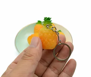Detail of a realistic pineapple keychain made of soft PVC material with a silver metal ring