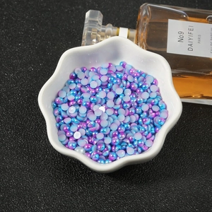 Iridescent blue and purple half-round faux pearls for DIY crafts in a white floral bowl