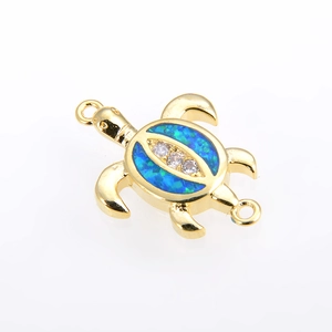 Close-up of a gold-plated turtle connector with blue opal and sparkling zircon stones
