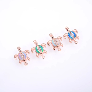 Detail of four rose gold turtle connectors with opal shells and zircon accents