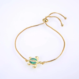 Close-up of golden turtle bracelet with green opal inlay and sliding adjustable clasp