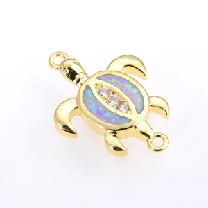 Detailed macro view of a gold turtle connector with colorful opal and zircon inlay