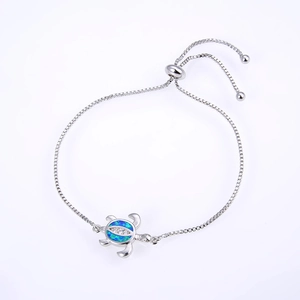 Detail of silver turtle bracelet featuring blue opal stone and adjustable box chain