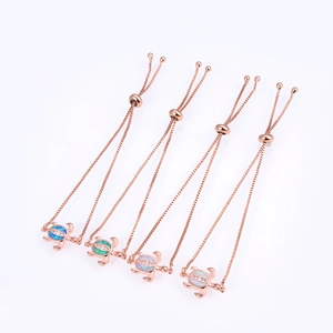 Macro detail of rose gold turtle bracelets with blue, green, and pink opal stone inlay