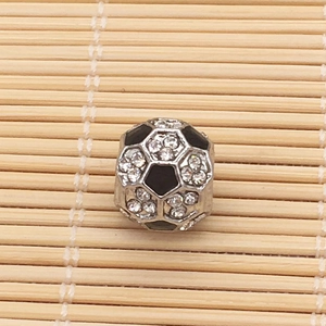 Macro shot of silver soccer charm bead with black enamel and sparkling rhinestones