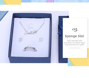 Close-up of smile necklace and pearl earrings in blue jewelry box with sponge insert