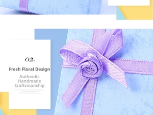 Detailed view of a blue textured jewelry gift box with a handmade purple ribbon rose
