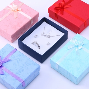 Multi-colored jewelry gift boxes with bows and elegant silver necklace and earring sets
