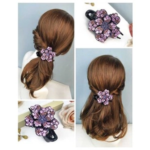 Detail of purple petal hair clip with rhinestones worn on long brown hair