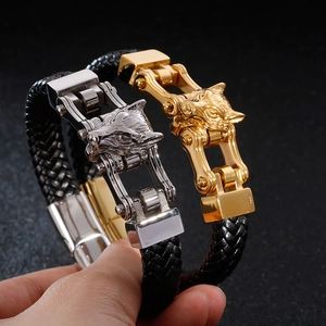 Men's braided leather bracelet featuring detailed silver and gold wolf head charms