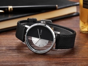 Detail view of the TOMI quartz watch featuring a split silver and black dial on wood surface