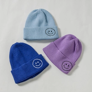Knitted beanie set in navy, light blue, and purple with embroidered smiley face patterns