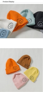 Close-up detail showing the classic smile embroidery and knit texture on colorful beanies