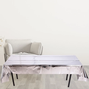 Detail of silver metallic foil tablecloth showing reflective texture in a room setting