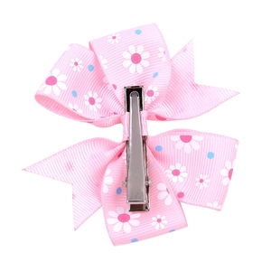 Macro detail of pink daisy printed ribbon bow showing the secure silver metal hair clip