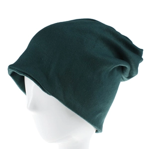 Dettaglio di un berretto in maglia verde scuro che mostra il tessuto su un supporto