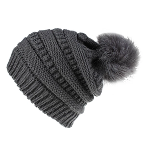 Nahaufnahme der dunkelgrauen Strickmütze mit flauschigem Kunstpelz-Bommel in Detailansicht