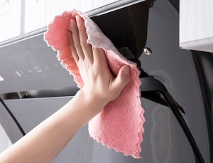 Hand wiping range hood with thick double-sided pink and grey microfibre cleaning cloth