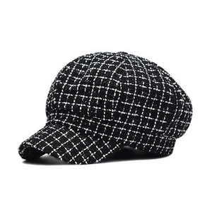 Detailed texture of black and white tweed fabric on a classic newsboy style hat