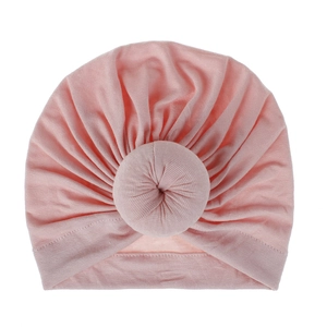 Close-up detail of a soft pink baby donut turban headwrap with pleated fabric texture