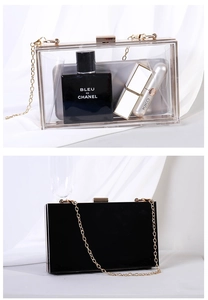 Detail of transparent acrylic and black glossy clutch bags with gold metal chains