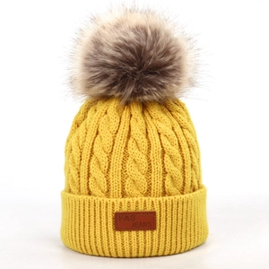 Bonnet en maille torsadée jaune pour enfants avec pompon en fausse fourrure et étiquette