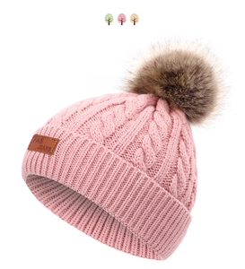 Détail du bonnet en maille rose avec pompon en fourrure et étiquette en cuir FAS JEANS