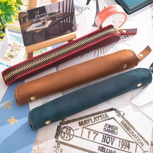 Three mini leather pouches in red, brown, and navy blue for coins and stationery