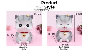 Detail of grey striped angel cat piggy bank with bell and closed eyes expression