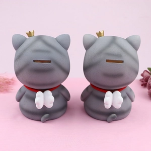 Rear view of two grey angel cat piggy banks with golden crowns and white wings