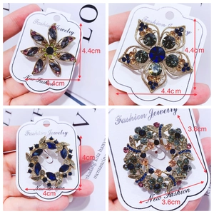 Detail of vintage crystal brooches in floral designs with gold plated alloy finish