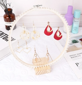 Detailed display of assorted lace earrings and pearl studs on a creative display stand