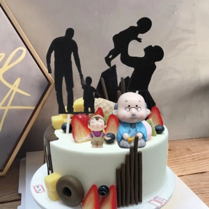 Close-up of birthday cake topper set featuring family silhouettes and 3D cartoon figures