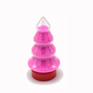 Détail du sable magique rose dans un récipient en forme de sapin avec base rouge